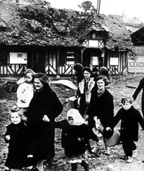 Rodziny opuszczające swoją wioskę bombardowane podczas lądowania w Normandii, Francja, 1944 r.