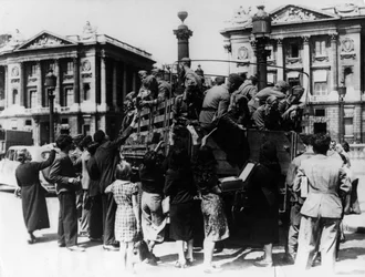 Francuscy sprzedawcy uliczni oferujący upominki ciężarówce żołnierzy niemieckich, Paryż, 27 lipca 1940 r