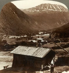 Ośnieżone szczyty góry Gausta 6180 stóp nad cichymi domami w dolinie Maan w Norwegii, ok. 1905 r.