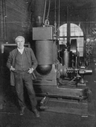 Thomas Alva Edison, amerykański wynalazca, ze swoim pierwszym dynamem do produkcji światła elektrycznego, lata 80. XIX wieku