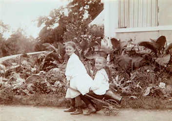 Dwoje dzieci bawiących się na świeżym powietrzu, lata 90. XIX wieku