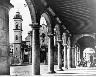Widok na Plac Starej Katedry w Hawanie jest obramowany wspaniałymi łukami sąsiedniego budynku, 1954 r.