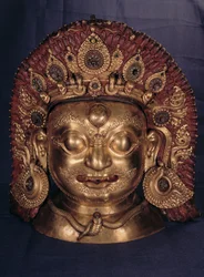 Głowa Bhairawy, koniec XVII w. (wytłaczana miedź, malowana i złocona)