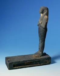 Figura Ptah-Sokar-Ozyrysa z trójstronną peruką i skrzyżowanymi ramionami na prostokątnym cokole z przegródką zawierającą fragment papirusu (patrz 83304), Egipt, 21-22 dynastia, ok. 900 pne (drewno) (szczegóły patrz 83306)