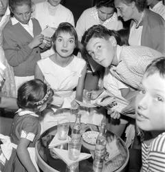 AKTORKA I MODELKA ELSA MARTINELLI NA XVIII MIĘDZYNARODOWYM FESTIWALU FILMOWYM NA LIDO W WENECJI (rozdaje autografy młodym wielbicielom. Na stole stoi butelka Schweppesa) - 1957
