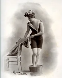Młoda kobieta w kostiumie kąpielowym (z Belle Epoque) podczas kąpieli stóp, około 1900 r. (zdjęcie czarno-białe)