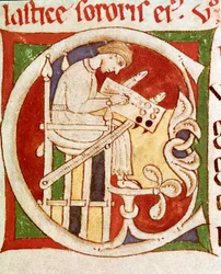 Litera C ozdobiona napisem mnich na biurku. Miniatura z „Vitae sanctorum” (Życie Świętych) Coimbre XII w., biblioteka uniwersytecka