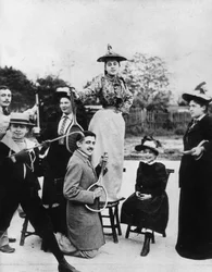 Marcel Proust (1871-1922) klęczący z rakietą tenisową przed Jeanne Ponquet stojącą na krześle w Neuilly (Francja) 1892