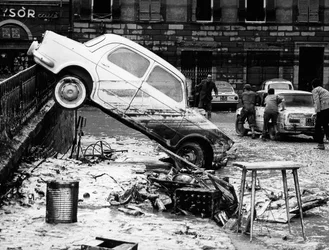 Samochód przerzucony przez balustradę na Via dei Renai podczas powodzi we Florencji, listopad 1966 r. (zdjęcie czarno-białe)