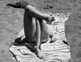 Kobiece nogi na plaży, ok. 1960 r. (zdjęcie czarno-białe)