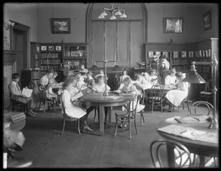 Dzieci czytające w czytelni niezidentyfikowanej filii Biblioteki Publicznej Queens Borough, ok. 1910 r.
