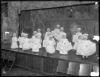 Przedszkolaki na scenie: bardzo małe dziewczynki występują na małej scenie, prawdopodobnie w rzymskokatolickim azylu dla sierot, Kingsbridge, Bronx, ok. 1911