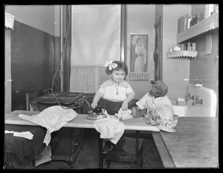 Niezidentyfikowana dziewczynka demonstrująca użycie żelazka elektrycznego, ok. 1913-14