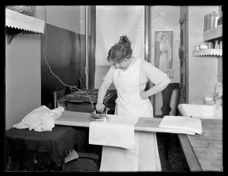 Niezidentyfikowana kobieta demonstruje użycie elektrycznego żelazka ok. 1913-14