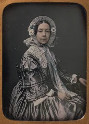 Siedząca kobieta w średnim wieku ubrana w eleganckie stroje, 1854-60.